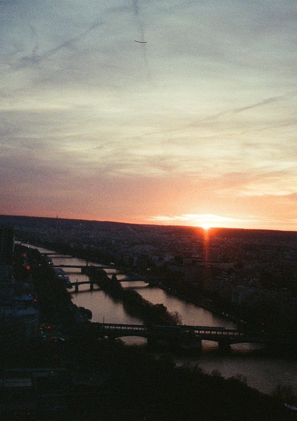 Sunset over Paris from above, the river and its bridges in silhouette